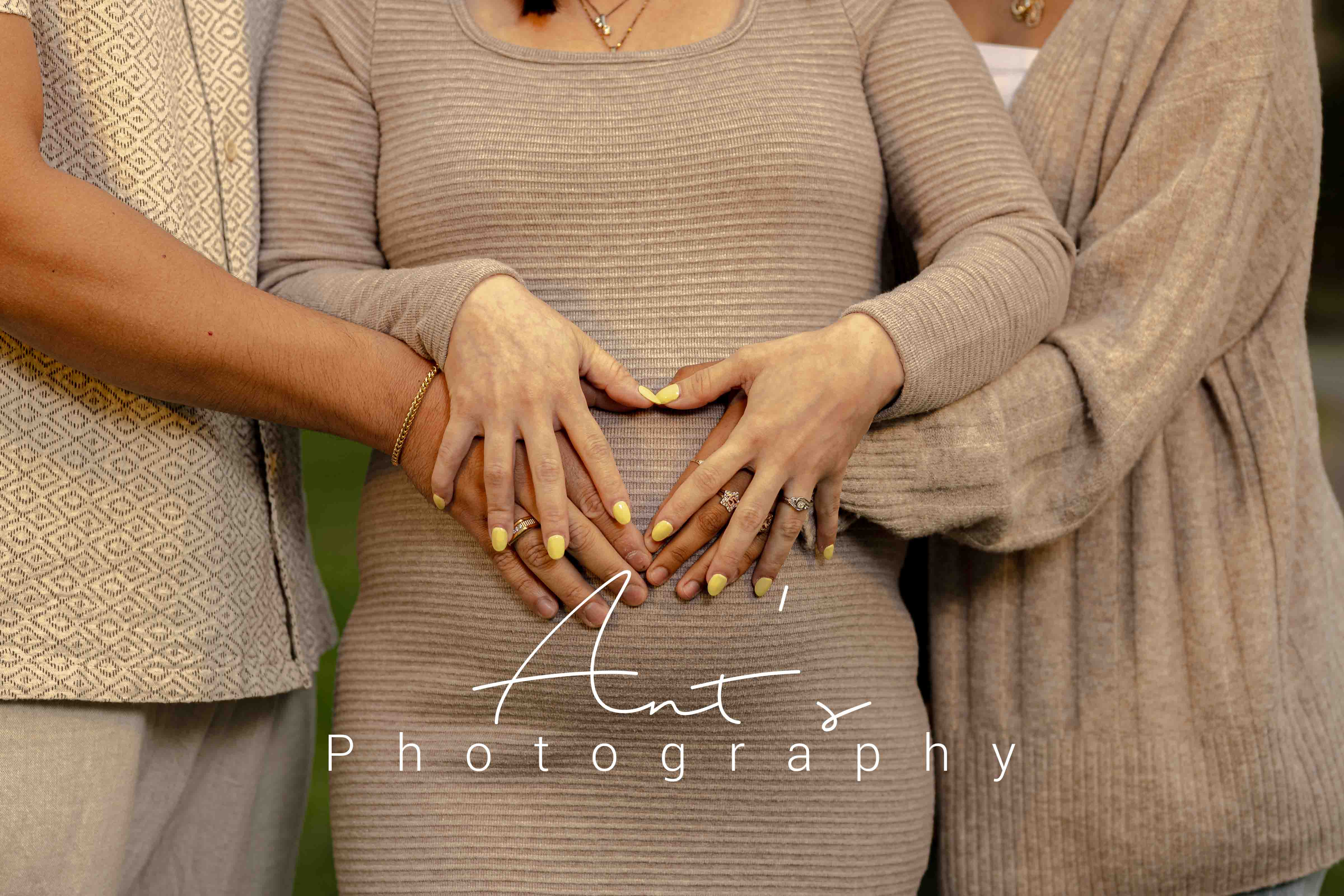 Close-up of hands resting on an expectant mother’s belly